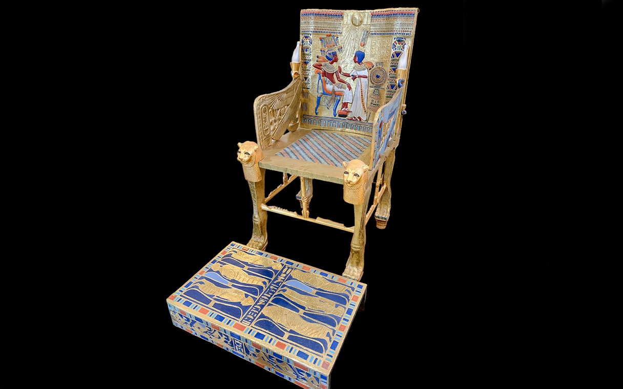 Golden throne with intricate hieroglyphics and pharaoh imagery, Tomb of the Pharaohs.