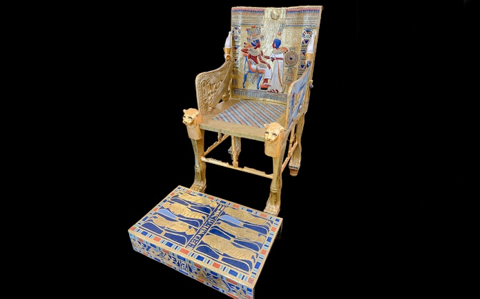 Golden throne with intricate hieroglyphics and pharaoh imagery, Tomb of the Pharaohs.