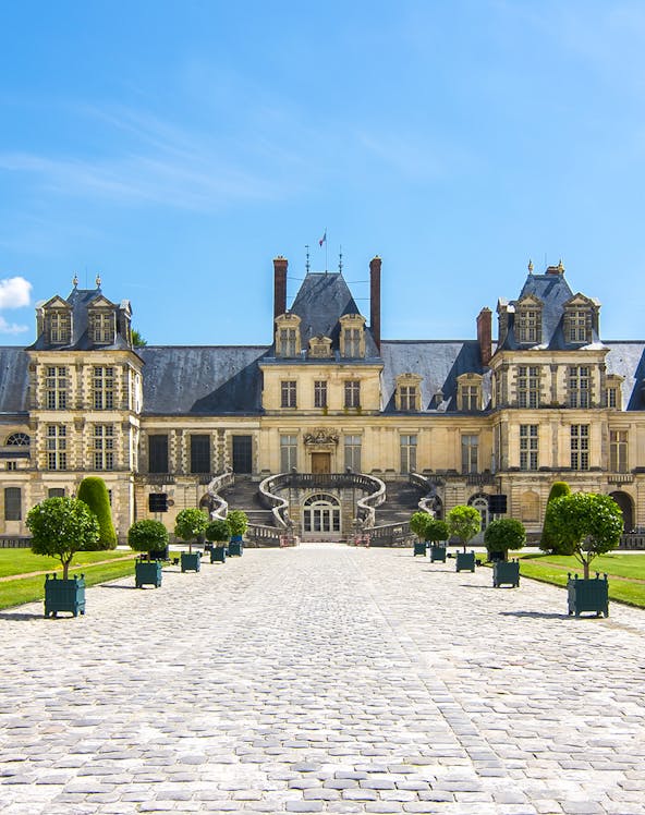 Château de Fontainebleau entrance with cobblestone path, near Paris, France.