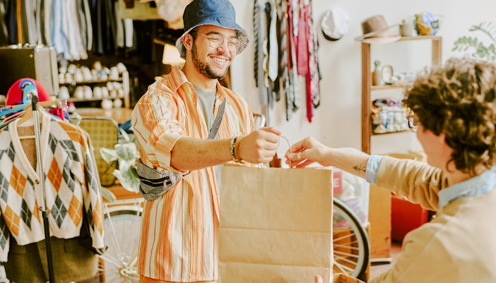 Person receiving a shopping bag at Lake Powell gift shop.