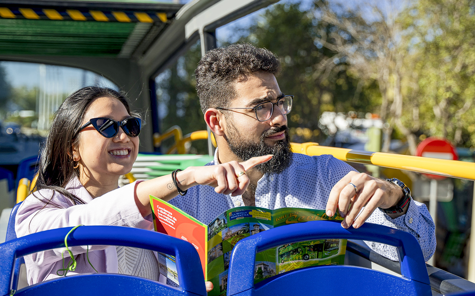 Couple enjoying Seville sights on Sevirama hop-on hop-off bus tour.