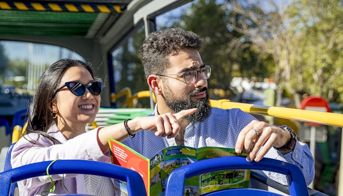 A couple viewing sights on the top deck of the bus