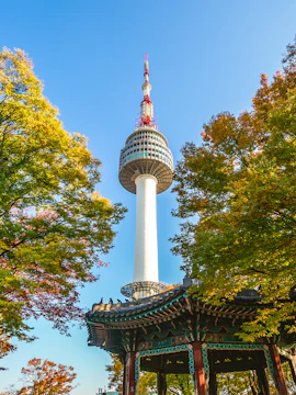 Namsan Seoul Tower rising above colorful autumn trees in Seoul, South Korea.