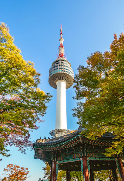 Namsan Seoul Tower rising above colorful autumn trees in Seoul, South Korea.
