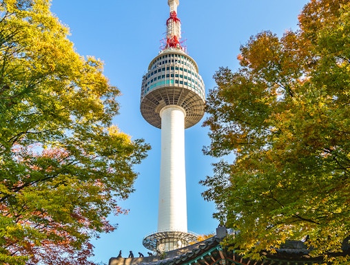 Namsan Seoul Tower rising above colorful autumn trees in Seoul, South Korea.