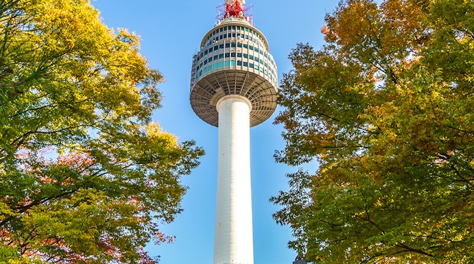 Namsan Seoul Tower rising above colorful autumn trees in Seoul, South Korea.
