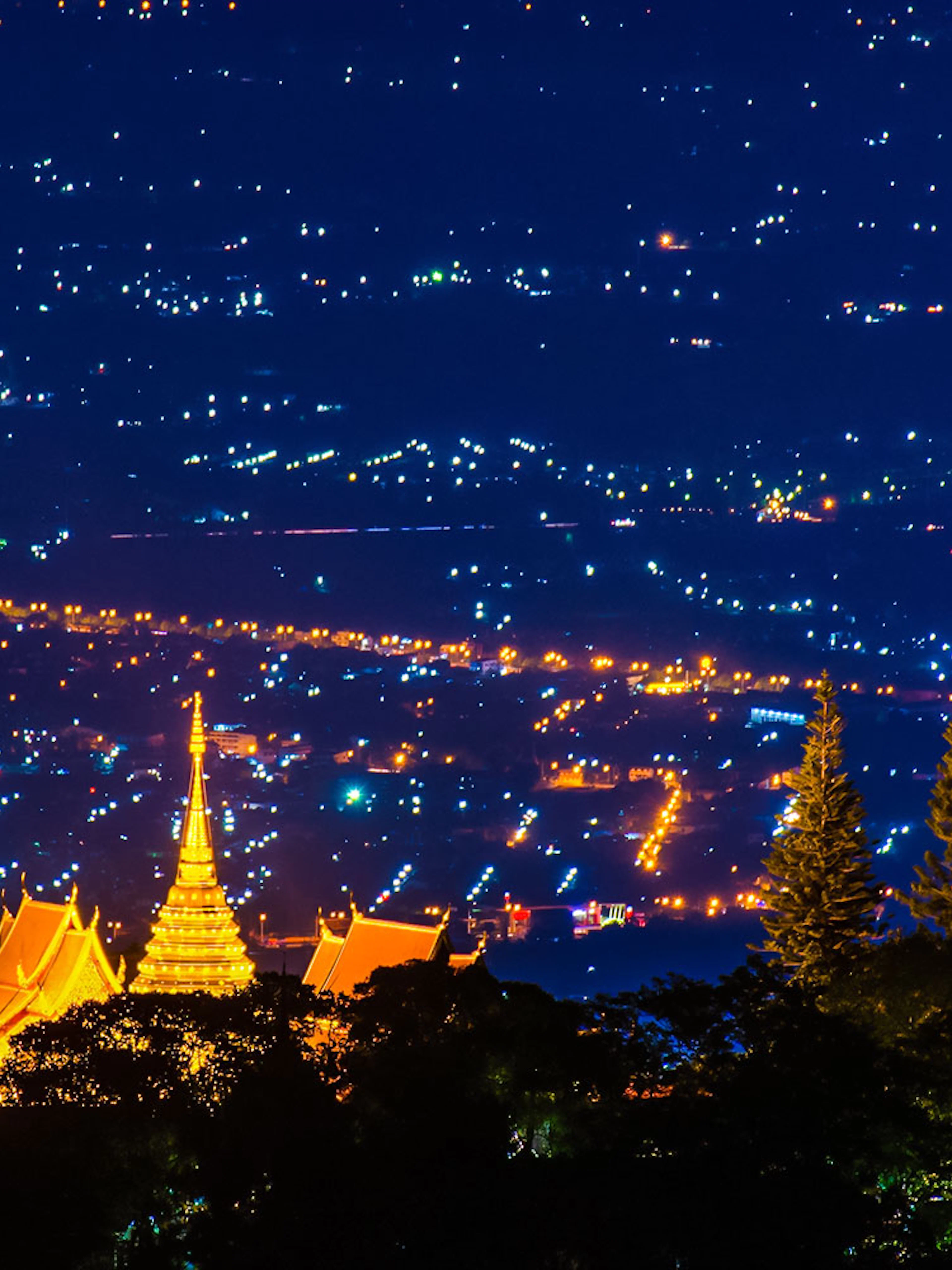 Wat Phra That Doi Suthep temple illuminated at night, overlooking Chiang Mai, Thailand.