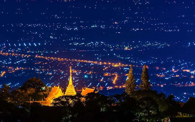 Wat Phra That Doi Suthep temple illuminated at night, overlooking Chiang Mai, Thailand.