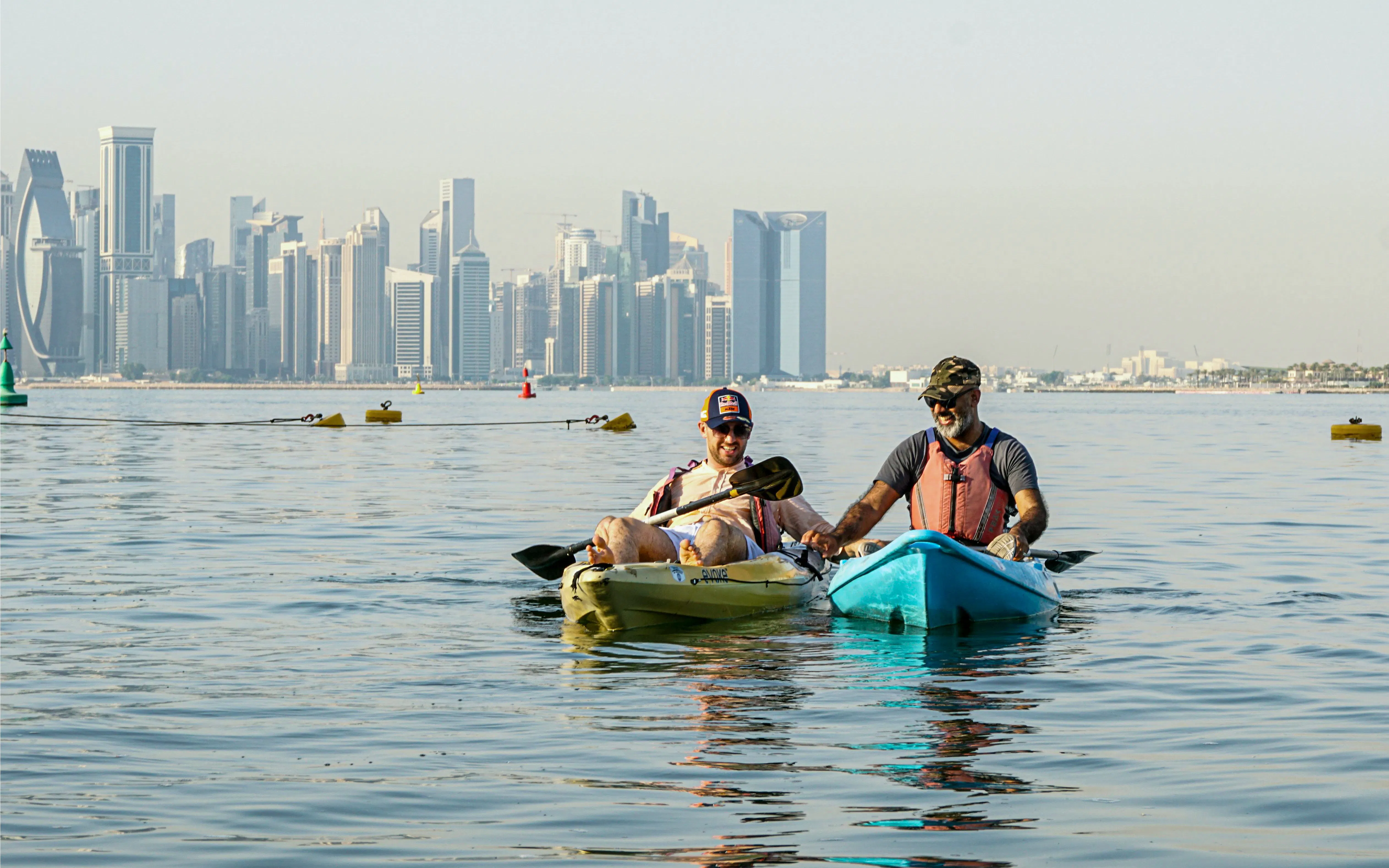Kayakers on The Pearl Guided Kayak Tour in Doha with city skyline in background.