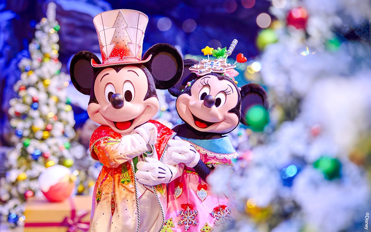 Mickey and Minnie in festive attire at Disneyland Christmas 2025 celebration.