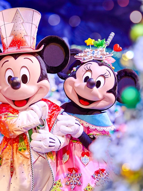 Mickey and Minnie in festive attire at Disneyland Christmas 2025 celebration.