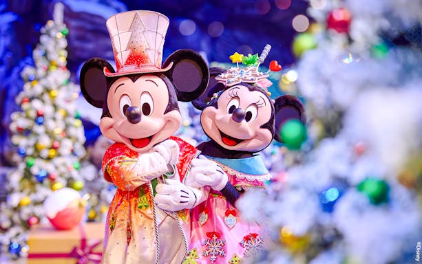Mickey and Minnie in festive attire at Disneyland Christmas 2025 celebration.