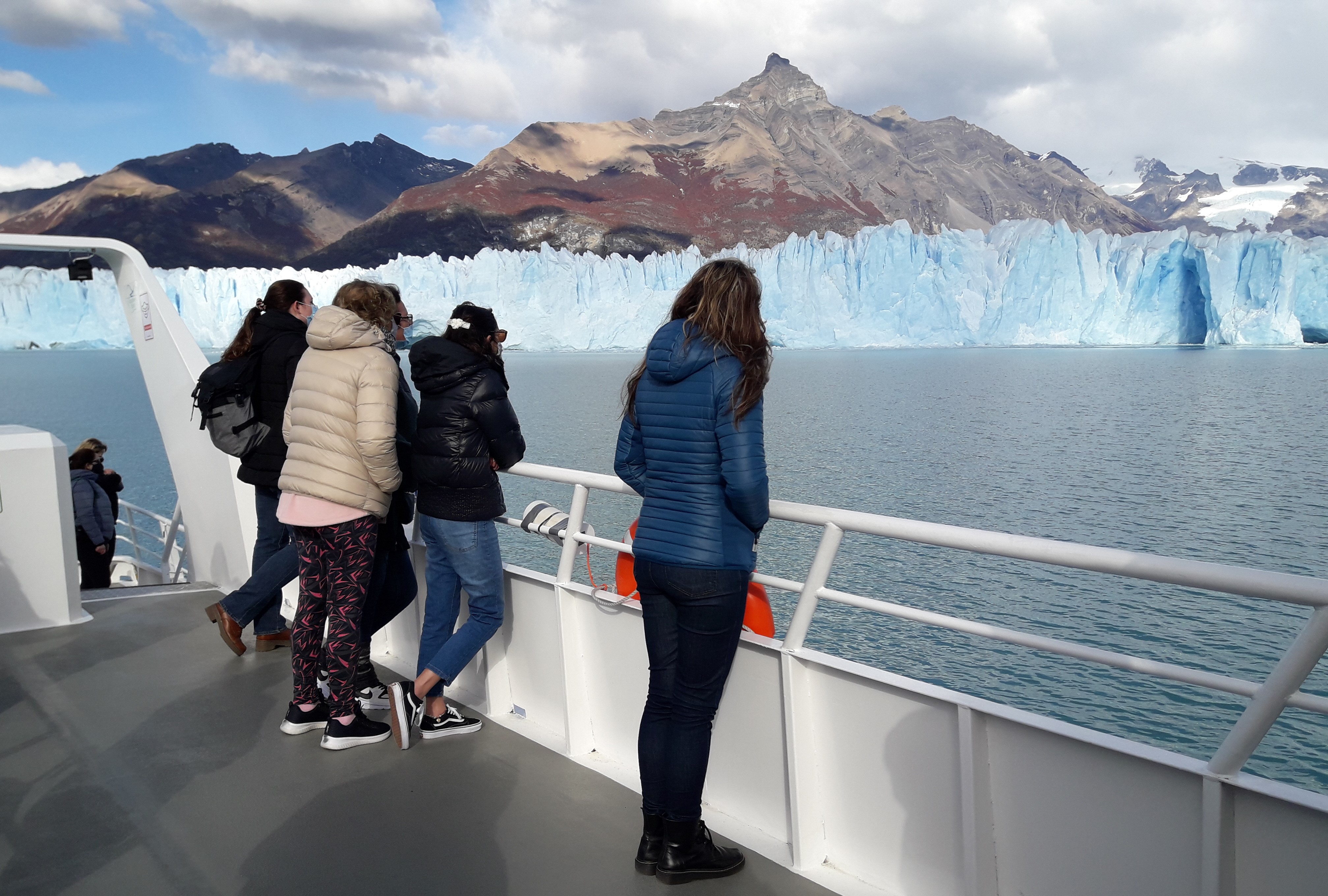 Tourists on cruise deck viewing Perito Moreno Glacier in Argentina.