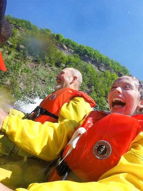 Guests enjoying Whirlpool Jet Boat Tour in Niagara Gorge, Canada, wearing life jackets.