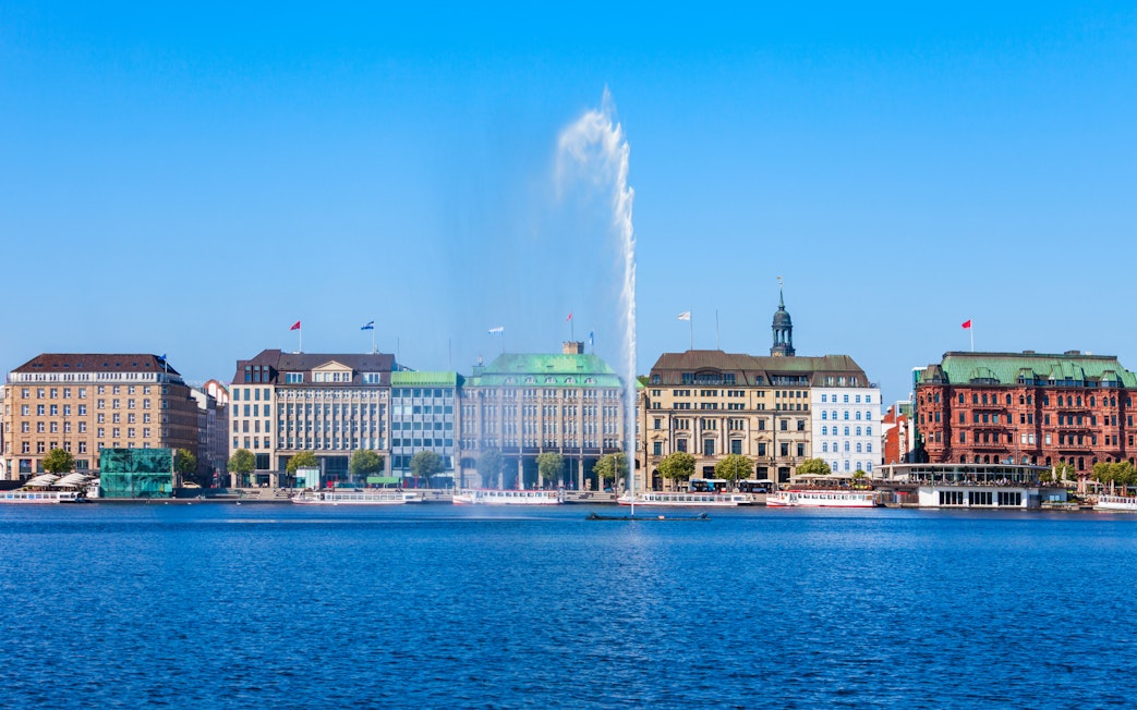 Hamburg cityscape with Alster Lake fountain, seen from a sightseeing cruise.