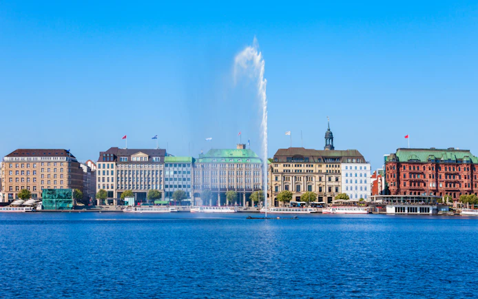 Hamburg cityscape with Alster Lake fountain, seen from a sightseeing cruise.