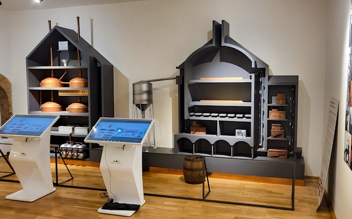 Interactive displays and brewing equipment inside Prague Beer Museum.