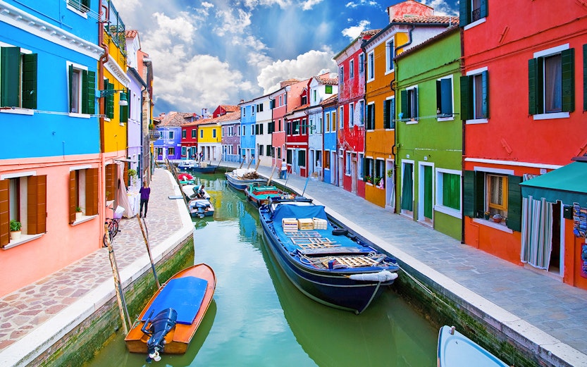 Colorful houses along a canal in Burano, Venice, Italy.