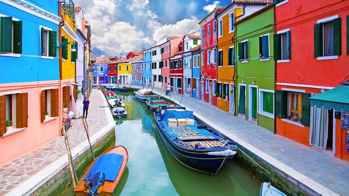 Colorful houses lining a canal on Murano and Burano islands in Venice, Italy.