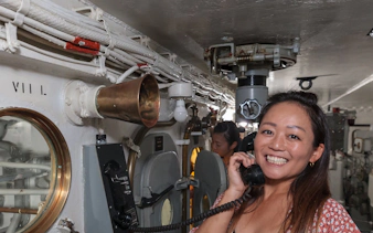 Visitor using phone on Battleship IOWA guided gun tour.