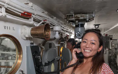 Visitor using phone on Battleship IOWA guided gun tour.
