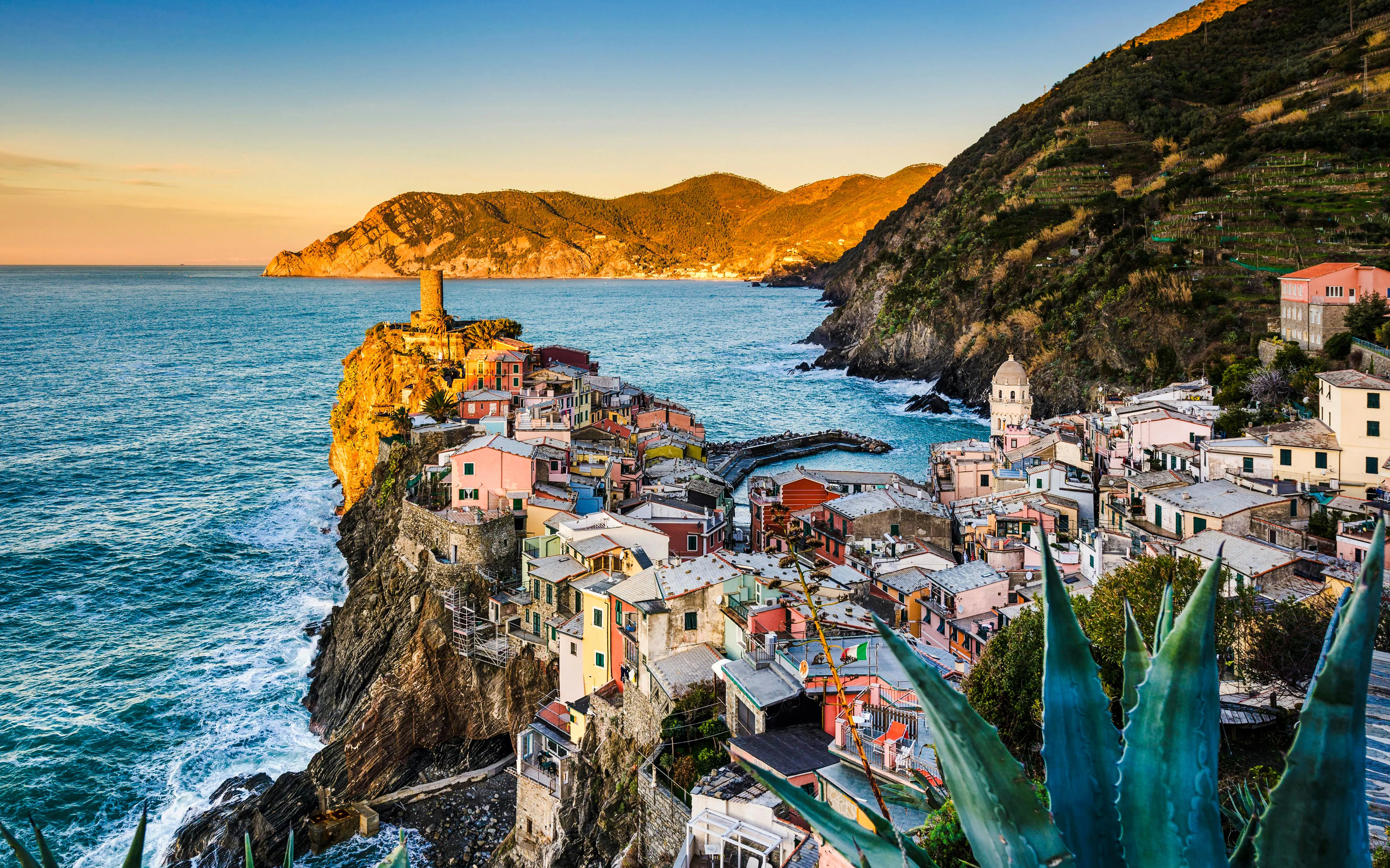 Vernazza coastline at sunrise with colorful buildings and sea view.