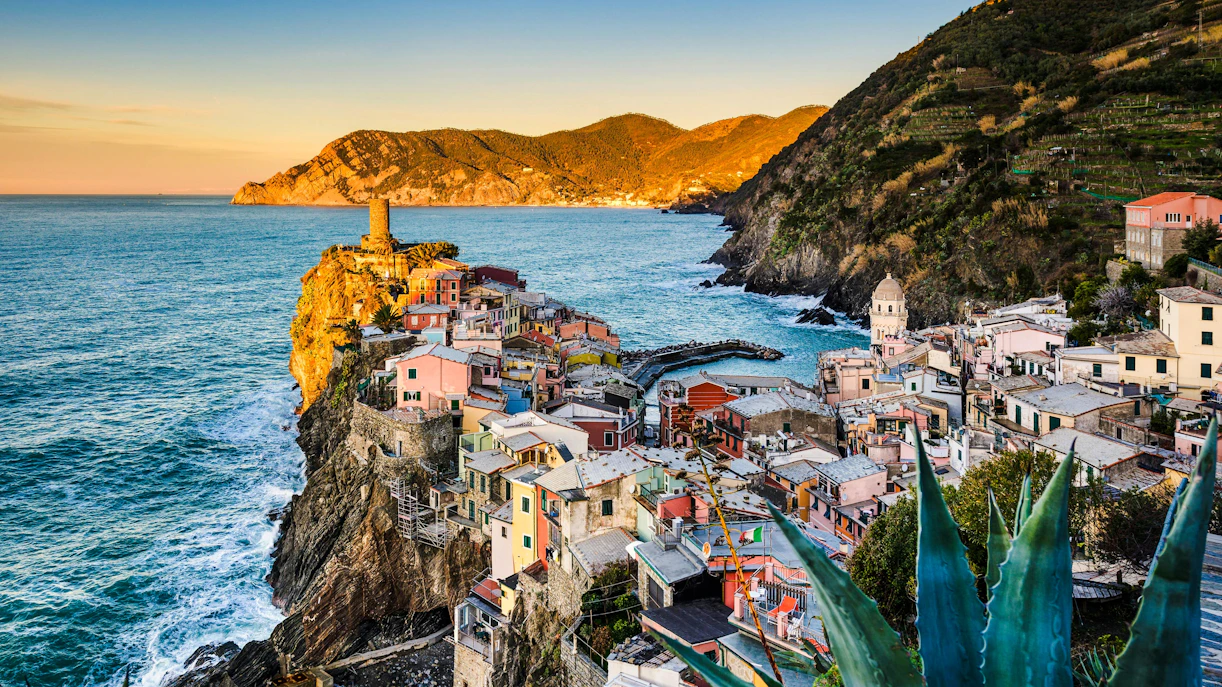 Vernazza coastline at sunrise with colorful buildings and sea view.