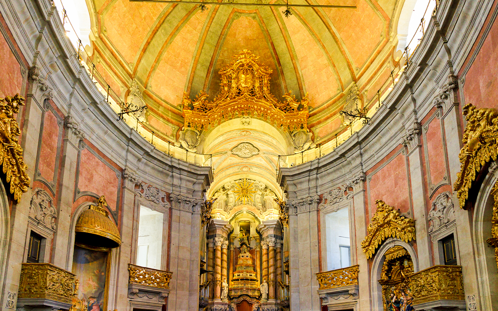 Interior of Clérigos Church in Porto, Portugal, showcasing Baroque architecture and ornate gold details.