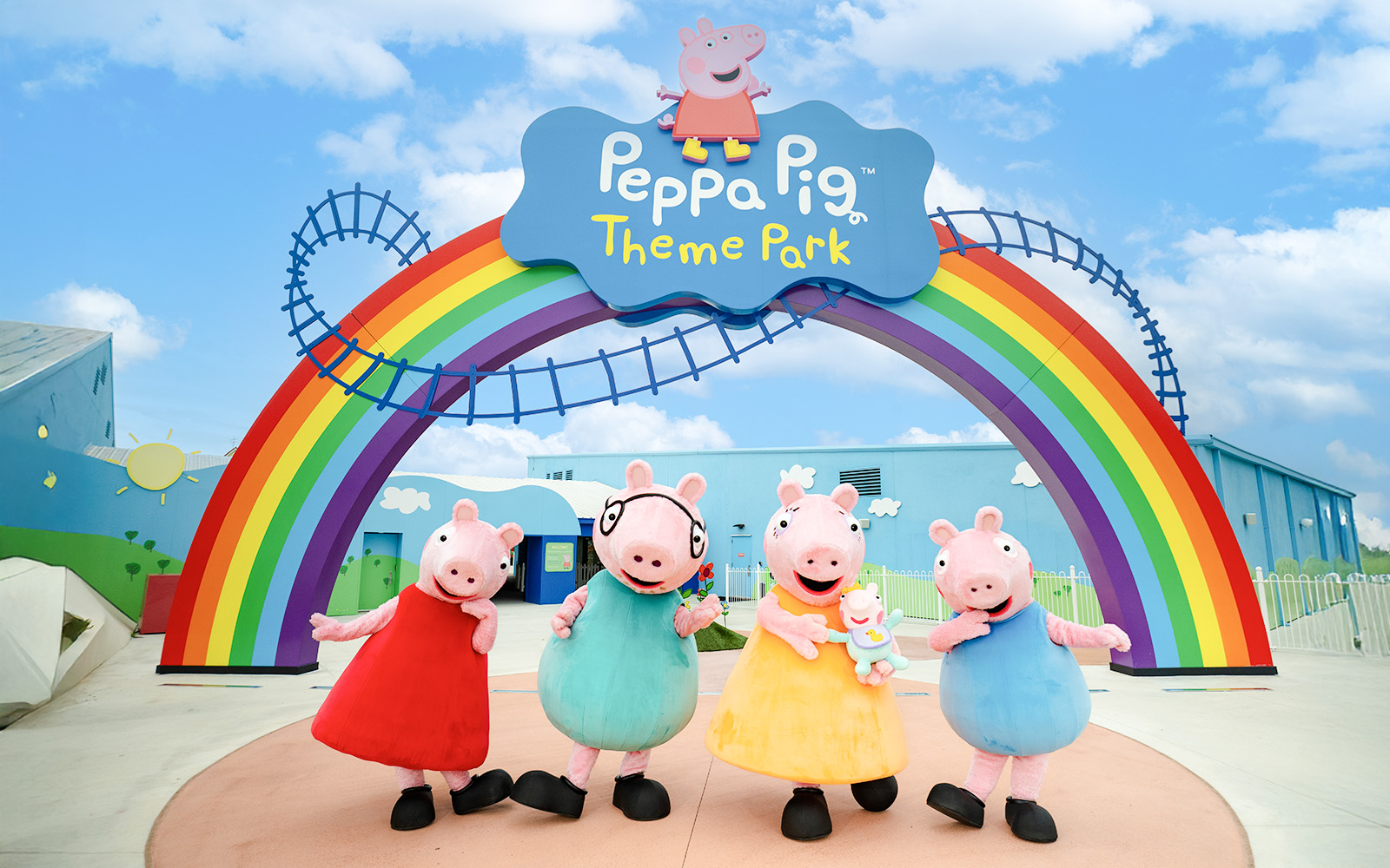 Peppa Pig characters under rainbow arch at Peppa Pig Theme Park, Florida.