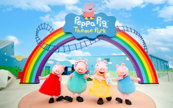 Peppa Pig characters under rainbow arch at Peppa Pig Theme Park, Florida.