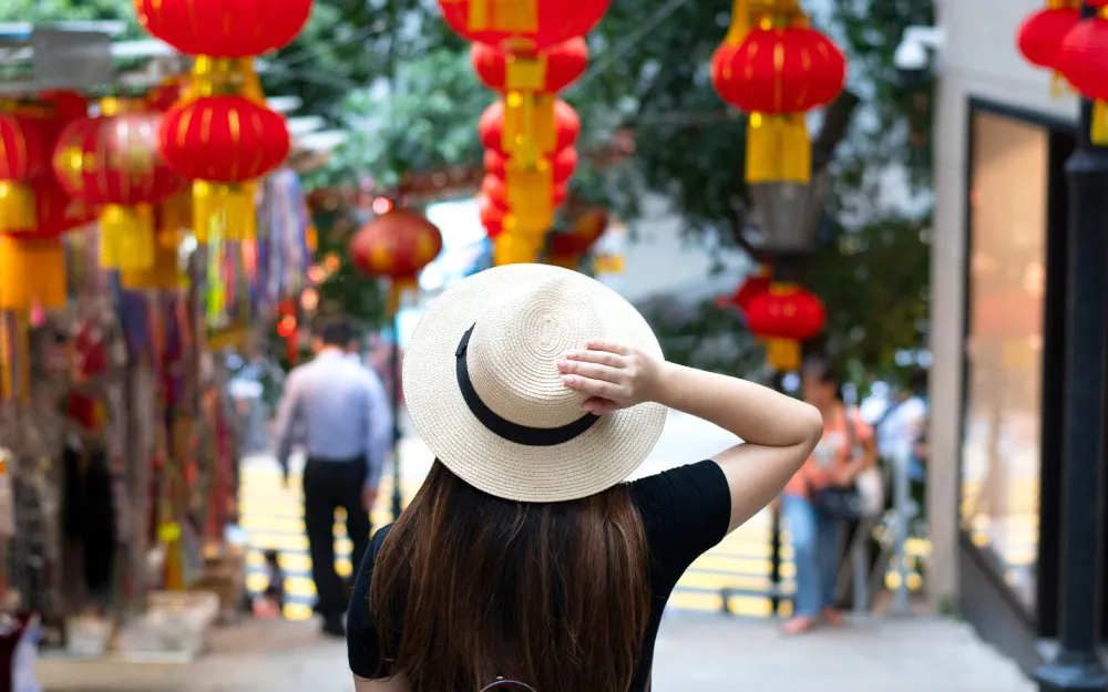 Person walking under red lanterns at Cheung Chau Bun Festival.