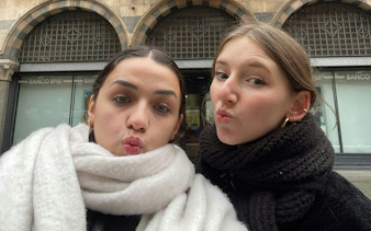 Two people posing playfully in front of Banco BPM, Milan, during a city exploration game.