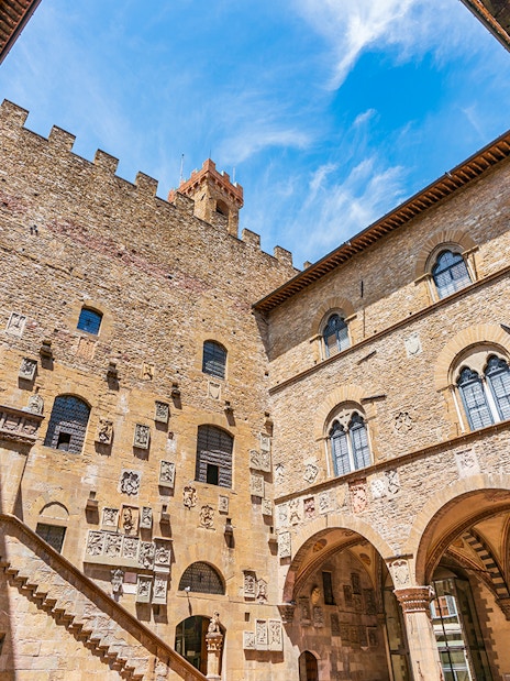 Museo del Bargello courtyard with stone walls and arched windows in Florence, Italy.