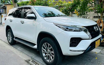 White SUV for Da Nang to Hoi An transfer service parked on a street.