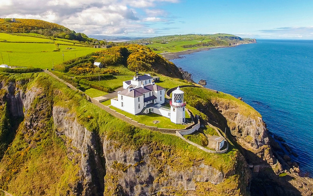 Blackhead Lighthouse on a cliff overlooking the sea in County Antrim, Northern Ireland.