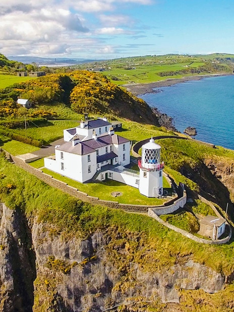 Blackhead Lighthouse on a cliff overlooking the sea in County Antrim, Northern Ireland.