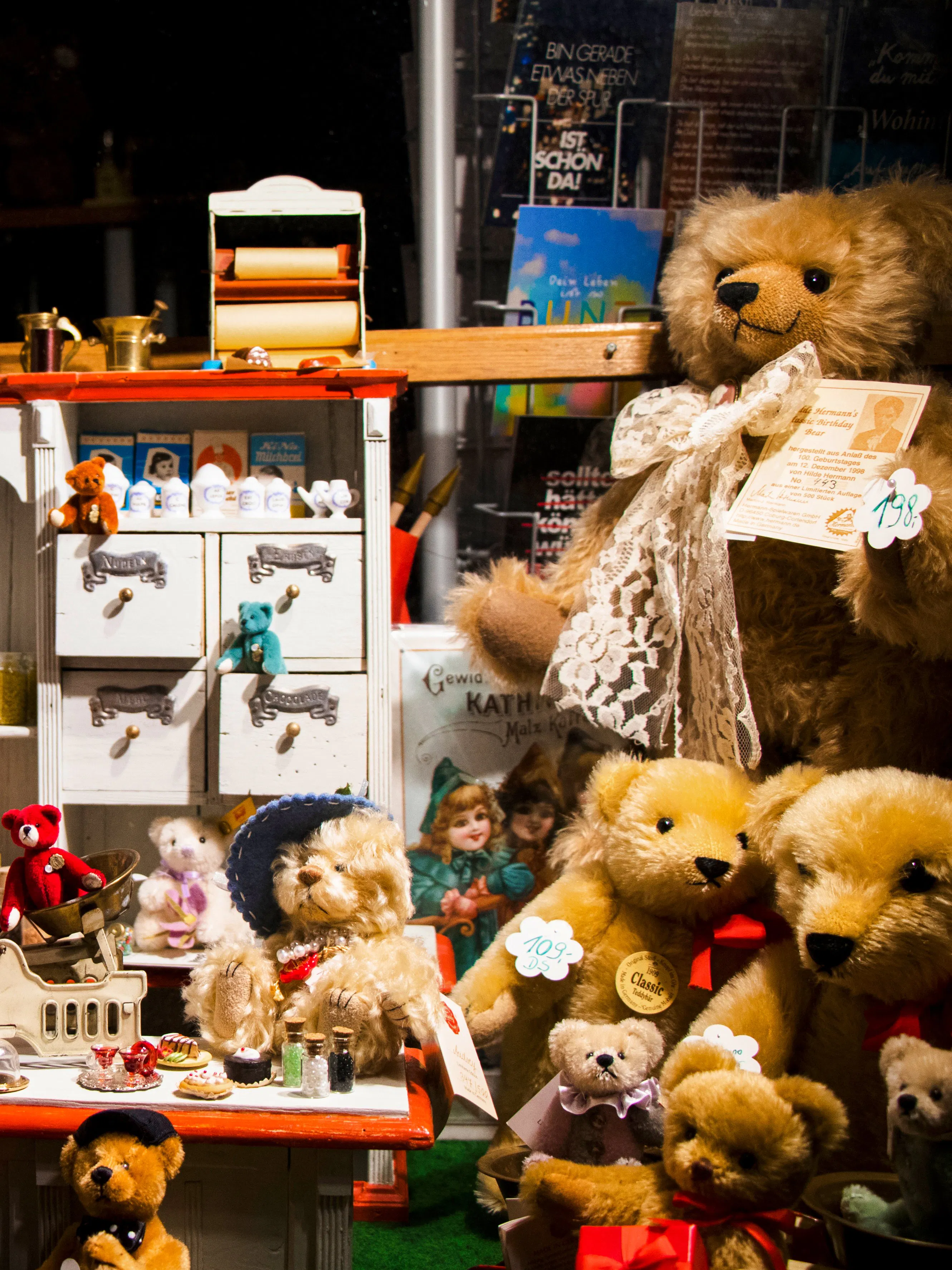 Teddy bears and vintage toys displayed on a magazine shelf.