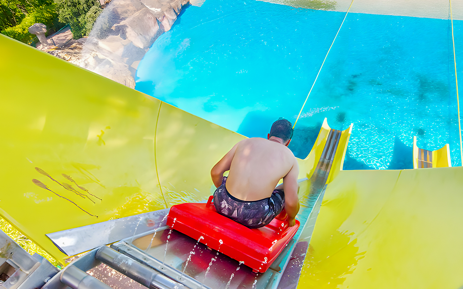 Man on a yellow water slide at Aquopolis Villanueva de la Cañada.