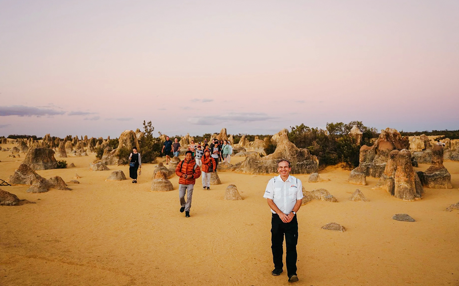 Tour group exploring Pinnacles Desert at sunset, Nambung National Park, Australia.