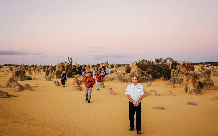 Tour group exploring Pinnacles Desert at sunset, Nambung National Park, Australia.
