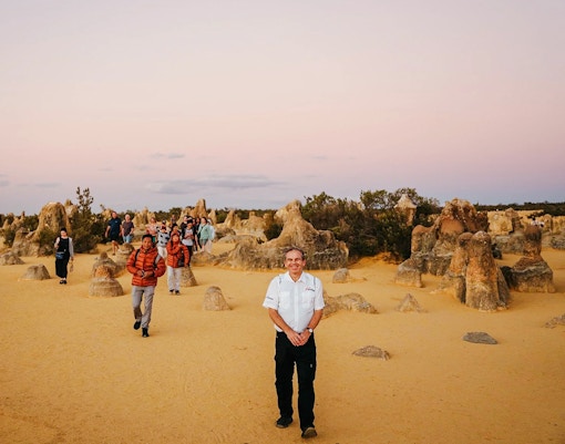 Tour group exploring Pinnacles Desert at sunset, Nambung National Park, Australia.