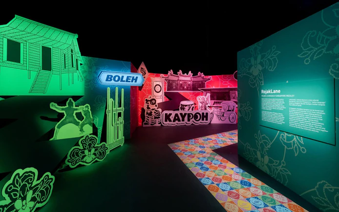 Exhibit featuring traditional Singaporean street scene with signage and cultural elements.