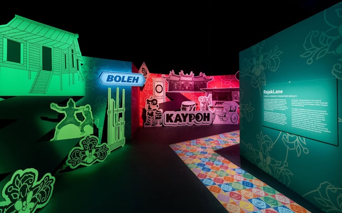Exhibit featuring traditional Singaporean street scene with signage and cultural elements.