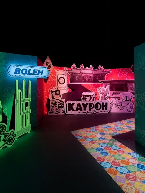 Exhibit featuring traditional Singaporean street scene with signage and cultural elements.