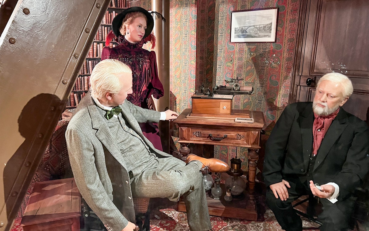 Wax figures in a vintage room, related to Eiffel Tower history, Paris.