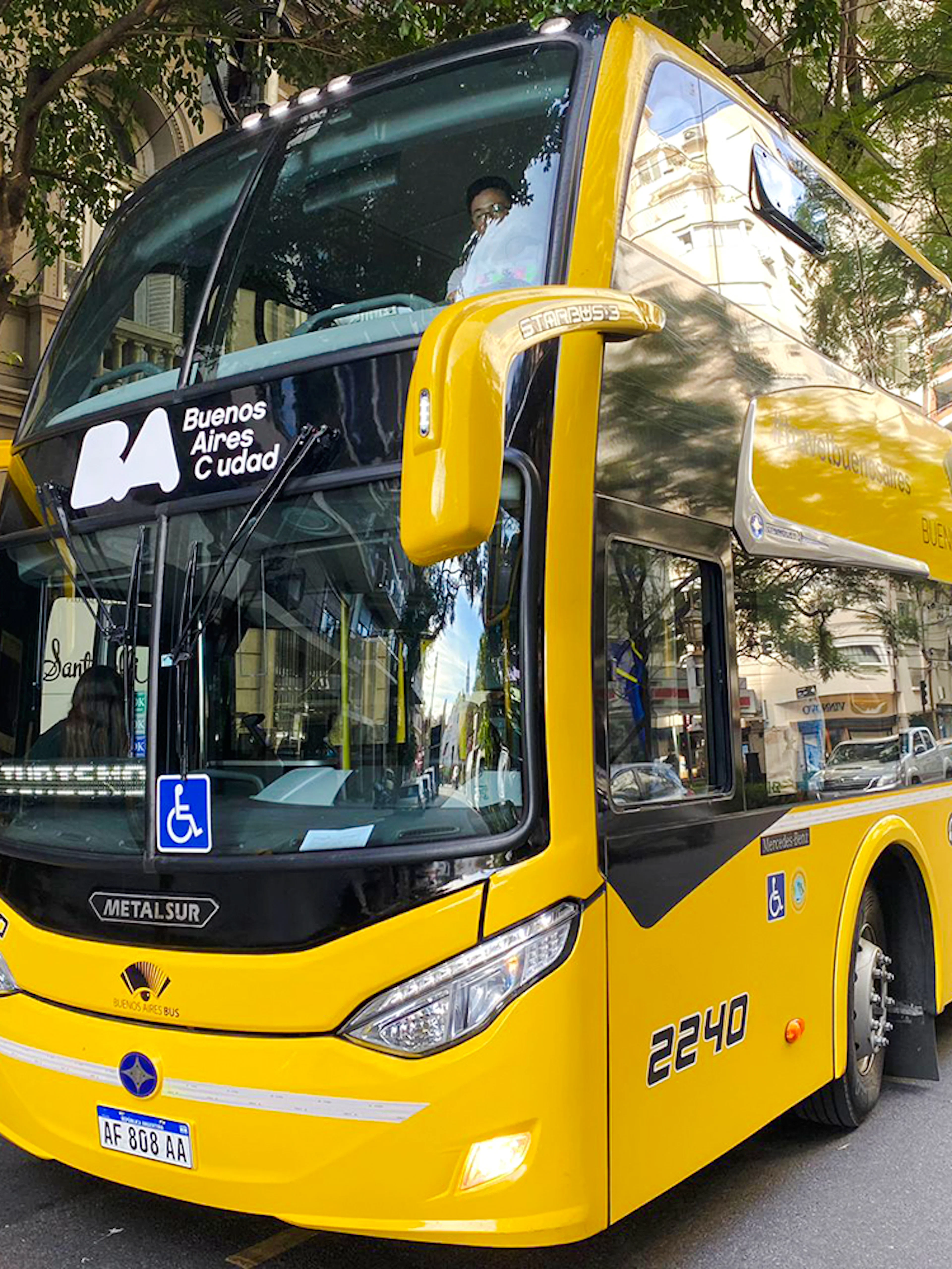 Double-decker tour bus in Buenos Aires city street.