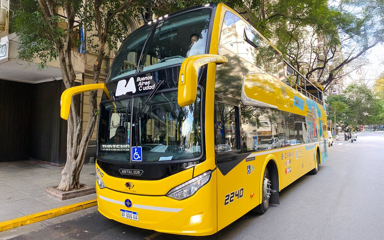 Double-decker tour bus in Buenos Aires city street.