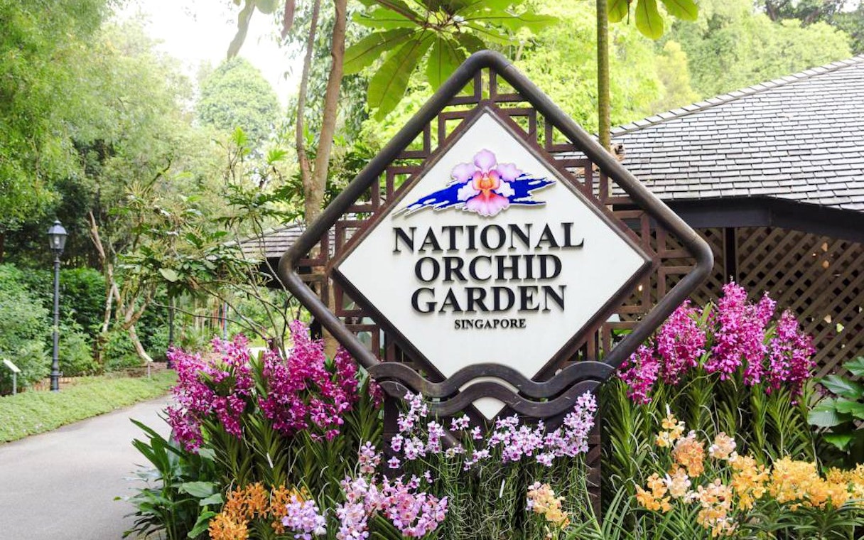 National Orchid Garden entrance sign surrounded by colorful orchids, Singapore.