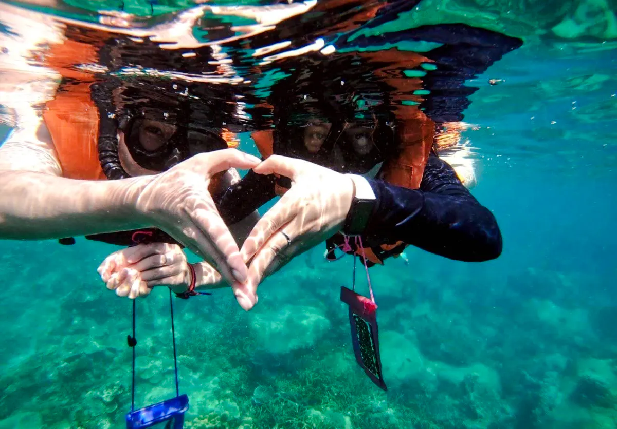Snorkelers form heart shape with hands underwater, Koh Tao tour, Koh Samui.