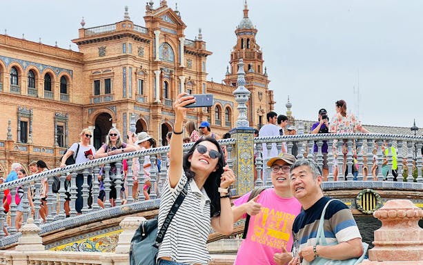 Tourists taking a selfie at Plaza de España, Seville, during a guided tour.